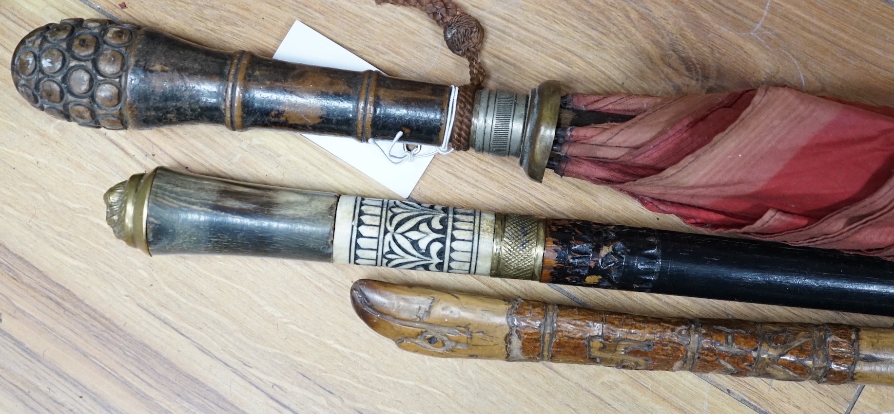 A bone and brass mounted ebonised sword stick, a Chinese umbrella and a cane